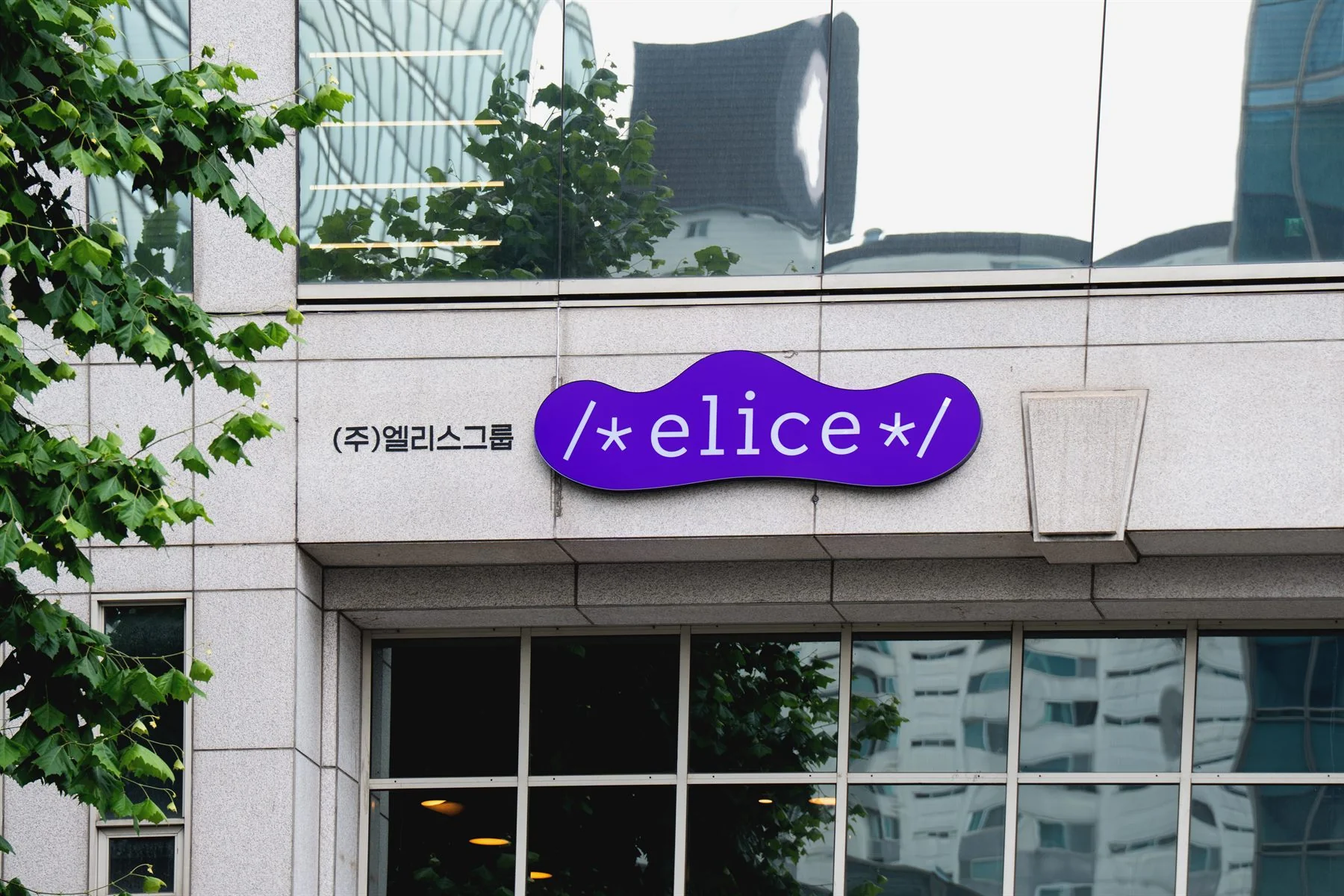 보라색 엘리스 간판이 걸린 사옥 외관